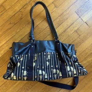 Black canvas weekender bag with gold arrows